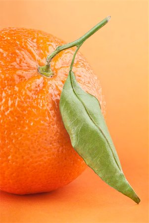 simsearch:400-04433511,k - Ripe tangerine with leaf on orange background Stock Photo - Budget Royalty-Free & Subscription, Code: 400-04402656