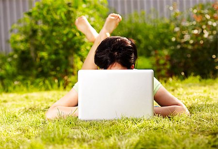 caucasian woman is lying on the grass with laptop Stock Photo - Budget Royalty-Free & Subscription, Code: 400-04403046