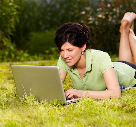 caucasian woman is sitting on the grass with laptop Stock Photo - Budget Royalty-Free & Subscription, Code: 400-04403056