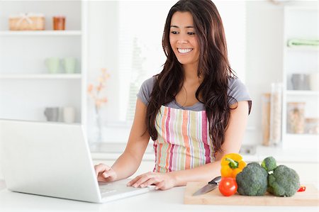 red pepper - Gorgeous woman relaxing with her laptop while standing in the kitchen Foto de stock - Super Valor sin royalties y Suscripción, Código: 400-04414820