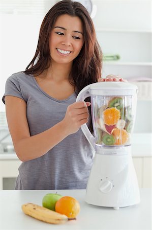 Beautiful woman using a blender while standing in the kitchen Stock Photo - Budget Royalty-Free & Subscription, Code: 400-04414842