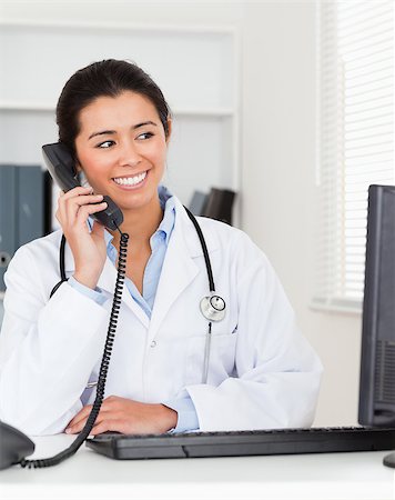 simsearch:400-05350424,k - Beautiful woman doctor on the phone while sitting in her office Foto de stock - Super Valor sin royalties y Suscripción, Código: 400-04415054