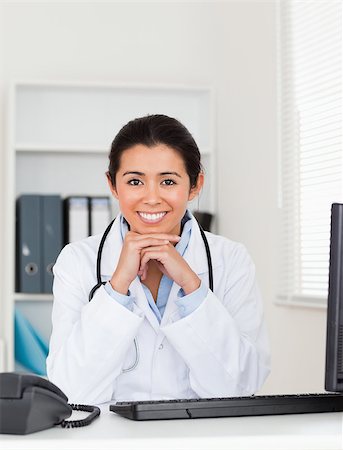 simsearch:400-05350424,k - Beautiful woman doctor posing while sitting in her office Foto de stock - Super Valor sin royalties y Suscripción, Código: 400-04415059