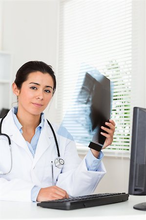 simsearch:400-05350424,k - Good looking female doctor looking at a x-ray in her office Foto de stock - Super Valor sin royalties y Suscripción, Código: 400-04415067