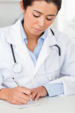 simsearch:400-05350424,k - Beautiful female doctor writing on a scratchpad in her office Foto de stock - Super Valor sin royalties y Suscripción, Código: 400-04415098