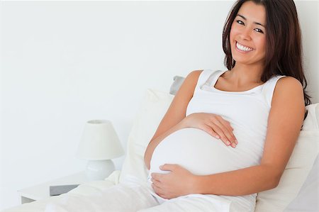 Beautiful pregnant woman posing while lying on a bed at home Stock Photo - Budget Royalty-Free & Subscription, Code: 400-04415107