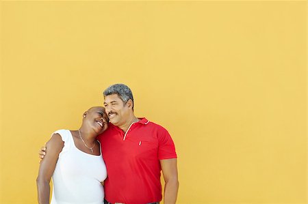 simsearch:400-04033107,k - mature latin american couple hugging and smiling with yellow wall in background. Waist up, copy space Stock Photo - Budget Royalty-Free & Subscription, Code: 400-04415258