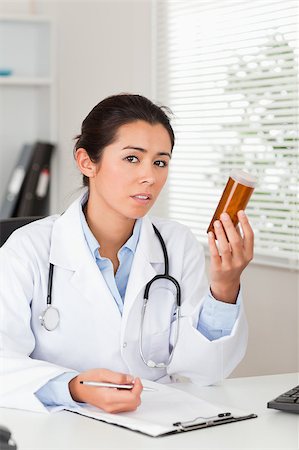 simsearch:400-05350424,k - Pretty worried doctor holding a box of pills in her office Foto de stock - Super Valor sin royalties y Suscripción, Código: 400-04415849