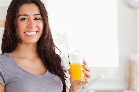 simsearch:400-04416091,k - Good looking woman holding a glass of orange juice while standing in the kitchen Fotografie stock - Microstock e Abbonamento, Codice: 400-04416106