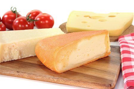 emmentaler cheese - a selection of cheeses with tomato on a wooden board Stock Photo - Budget Royalty-Free & Subscription, Code: 400-04416277