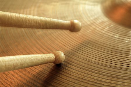 Photo of two drumsticks playing on a hi-hat or ride cymbal.  Focus on tip of lower stick while other stick has slight motion. Foto de stock - Super Valor sin royalties y Suscripción, Código: 400-04416708