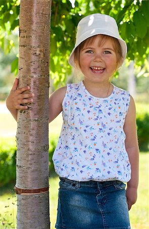 raysay (artist) - Little adorable girl posing by tree in the park Foto de stock - Royalty-Free Super Valor e Assinatura, Número: 400-04416793