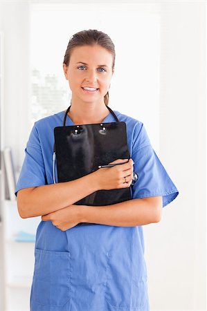 simsearch:400-04024679,k - Cute nurse holding a folder while looking at the camera Stockbilder - Microstock & Abonnement, Bildnummer: 400-04417340