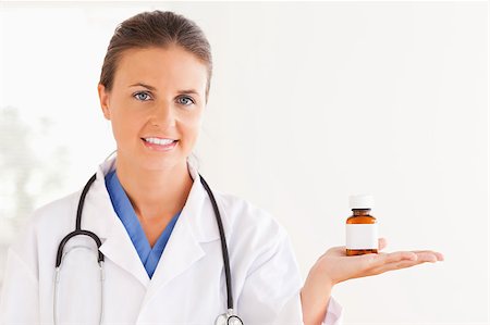 simsearch:400-05728493,k - Portrait of a brunette doctor looking at some pills in the surgery Photographie de stock - Aubaine LD & Abonnement, Code: 400-04417384