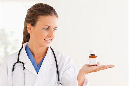 simsearch:400-05728490,k - Good looking doctor looking at some pills in the surgery Photographie de stock - Aubaine LD & Abonnement, Code: 400-04417385