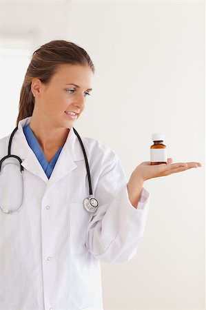 simsearch:400-05728490,k - Good looking brunette doctor looking at some pills in the surgery Photographie de stock - Aubaine LD & Abonnement, Code: 400-04417386