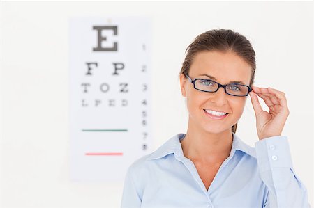 surgery eyes - Good looking eye specialist wearing glasses looking into the camera in her surgery Stock Photo - Budget Royalty-Free & Subscription, Code: 400-04417396