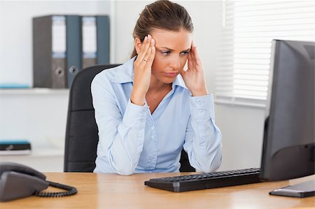 phone with pain - A stressed businesswoman is sitting in an office and looking to the screen Stock Photo - Budget Royalty-Free & Subscription, Code: 400-04417408