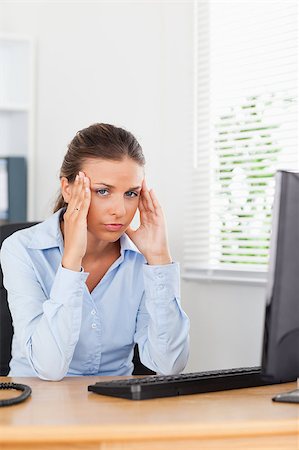 phone with pain - A stressed businesswoman is having a headache in an office Stock Photo - Budget Royalty-Free & Subscription, Code: 400-04417410