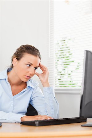 phone with pain - A frustrated looking businesswoman is looking to the screen of her pc in an office Stock Photo - Budget Royalty-Free & Subscription, Code: 400-04417411