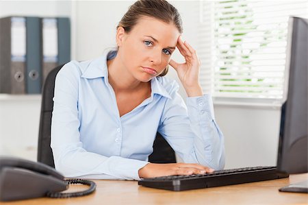 phone with pain - A sad businesswoman is looking into the camera in an office Stock Photo - Budget Royalty-Free & Subscription, Code: 400-04417412