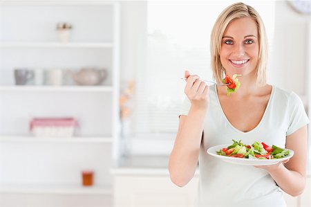 simsearch:400-05751129,k - Close up of a cute woman eating salad in the kitchen Stockbilder - Microstock & Abonnement, Bildnummer: 400-04417484