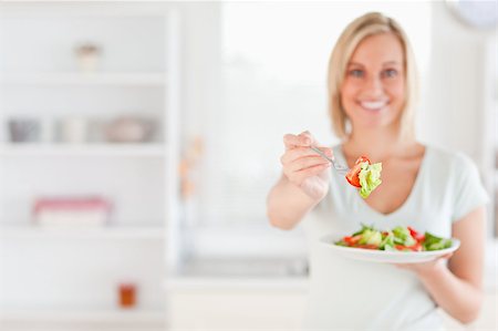 simsearch:400-05751129,k - Woman offering salad in her kitchen Stockbilder - Microstock & Abonnement, Bildnummer: 400-04417498