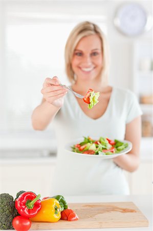 simsearch:400-05751129,k - Beautiful woman offering salad in the kitchen Stockbilder - Microstock & Abonnement, Bildnummer: 400-04417511