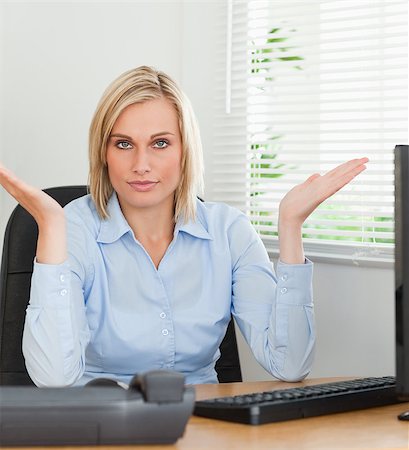 simsearch:400-04894274,k - Serious woman sitting behind desk not having a clue what to do next in an office Stock Photo - Budget Royalty-Free & Subscription, Code: 400-04417558