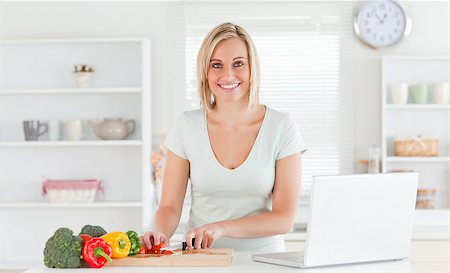 simsearch:400-05748090,k - Close up of a young woman looking into camera while cutting peppers in kitchen Foto de stock - Super Valor sin royalties y Suscripción, Código: 400-04417642