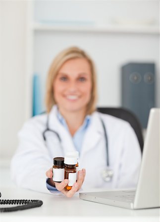 simsearch:400-04417775,k - Smiling doctor presenting medicine in her office Foto de stock - Super Valor sin royalties y Suscripción, Código: 400-04417744