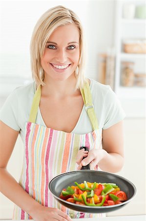 simsearch:400-08021946,k - Woman showing a pan with peppers in the kitchen Stock Photo - Budget Royalty-Free & Subscription, Code: 400-04417748