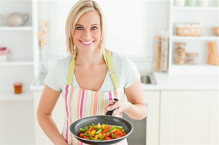 simsearch:400-04139196,k - Woman with filled pan looking into the camera in the kitchen Foto de stock - Royalty-Free Super Valor e Assinatura, Número: 400-04417765