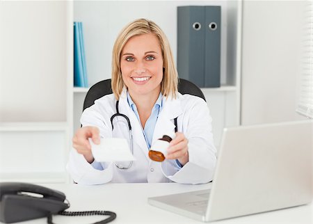 simsearch:400-04417775,k - Charming doctor holding prescription and medicine to camera in her office Foto de stock - Super Valor sin royalties y Suscripción, Código: 400-04417766