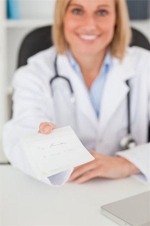 simsearch:400-04417775,k - Smiling blonde doctor giving prescription looks into camera in her office Foto de stock - Super Valor sin royalties y Suscripción, Código: 400-04417763