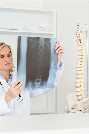 simsearch:400-04417775,k - Sad looking doctor holding x-ray looking at it in her office Foto de stock - Super Valor sin royalties y Suscripción, Código: 400-04417772