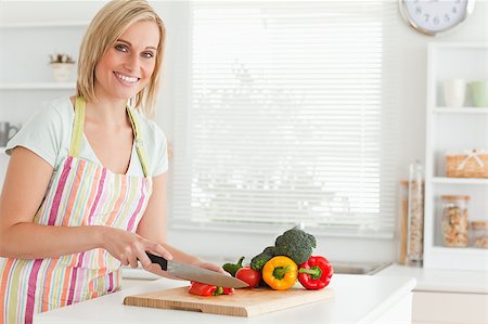 simsearch:400-05748090,k - Cute woman cutting red pepper looks into camera in kitchen Foto de stock - Super Valor sin royalties y Suscripción, Código: 400-04417809