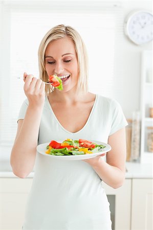 simsearch:400-05751129,k - Portrait of a blonde woman enjoying mixed salad in kitchen Stockbilder - Microstock & Abonnement, Bildnummer: 400-04417815