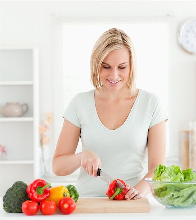 simsearch:400-05748090,k - Cute woman cutting vegetables in her kitchen Foto de stock - Super Valor sin royalties y Suscripción, Código: 400-04417810