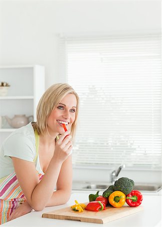 simsearch:400-04853599,k - Portrait of a young woman eating red peppers in kitchen Foto de stock - Royalty-Free Super Valor e Assinatura, Número: 400-04417813