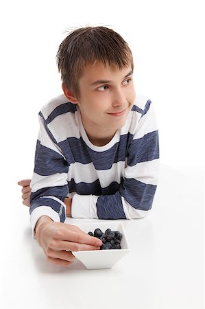 Boy with a bowl of berries.  He is looking sideways, suitable for message.  White background. Photographie de stock - Aubaine LD & Abonnement, Code: 400-04418037