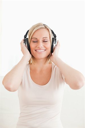 simsearch:400-04418452,k - Portrait of a lovely woman listening to music against a white background Photographie de stock - Aubaine LD & Abonnement, Code: 400-04418454