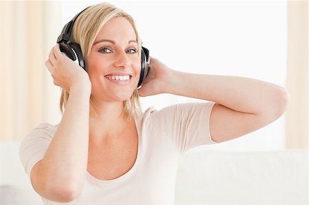 simsearch:400-04418452,k - Close up of a cute woman enjoying some music while looking at the camera Photographie de stock - Aubaine LD & Abonnement, Code: 400-04418452