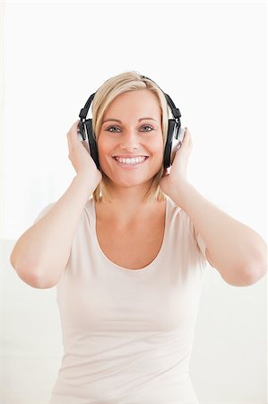 simsearch:400-04418454,k - Portrait of a lovely woman enjoying some music against a white background Foto de stock - Royalty-Free Super Valor e Assinatura, Número: 400-04418453