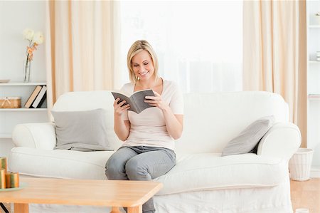 simsearch:400-04905604,k - Blond-haired woman reading a book in her living room Stockbilder - Microstock & Abonnement, Bildnummer: 400-04418462