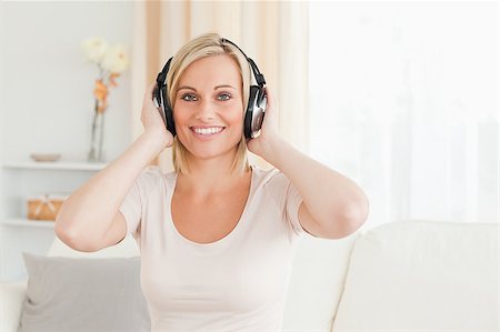 simsearch:400-04418454,k - Smiling woman with headhones  in her living room Stockbilder - Microstock & Abonnement, Bildnummer: 400-04418520