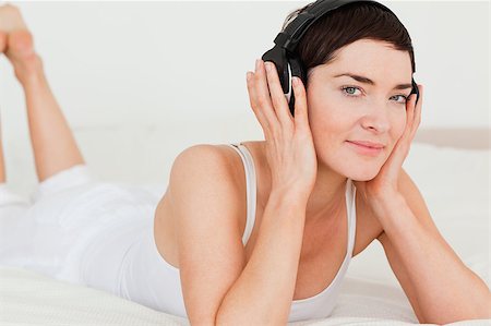 Young brunette listening to music while looking at the camera Stock Photo - Budget Royalty-Free & Subscription, Code: 400-04410524