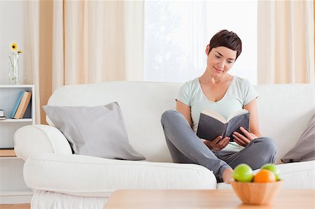 simsearch:400-04688796,k - Lovely woman reading a book in her living room Fotografie stock - Microstock e Abbonamento, Codice: 400-04410540