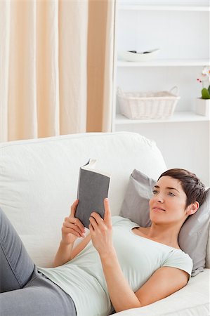 Portrait of a beautiful brunette reading a book while looking at the camera Stock Photo - Budget Royalty-Free & Subscription, Code: 400-04410586