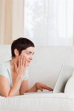 simsearch:400-05209351,k - Portrait of a surpised woman using a laptop in her living room Stock Photo - Budget Royalty-Free & Subscription, Code: 400-04410645